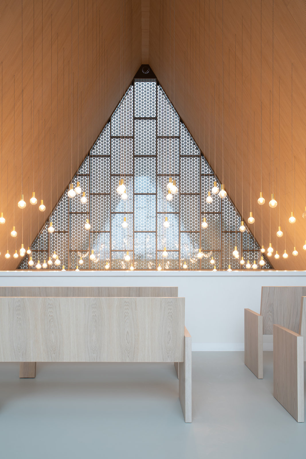 Interiér obřadní síně s akustickými panely Novatop - cílem bylo vytvořit architekturu, která neupřednostňuje sama sebe, ale citlivě rámuje lidské prožitky. (Rekonstrukce obřadní síně v Přerově; KT architekti)