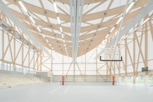 Konstrukce haly je ze dřeva, fasádu pak tvoří speciální textilní membrána. (Sportovní a kulturní centrum Marie-Jose Perec a Josephine Baker v La Bouëxière ve Francii; onze04)