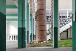 Některé z komínů zůstaly zachované jako odkaz na industriální minulost. (Transformace Výstavního paláce v Charleroi CHAPEX; AgwA a architecten jan de vylder inge vinck )