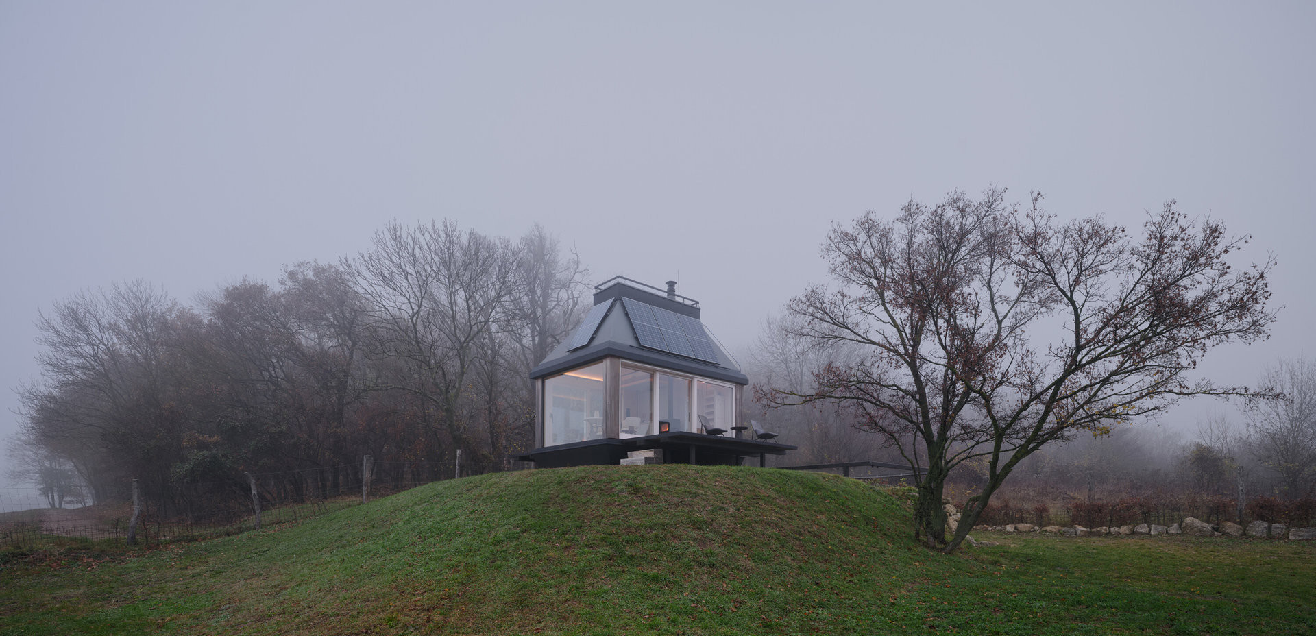 Chata stojí na kopci přímo ve vinici. (Domek ve vinici; Ark-Shelter, Archekta)