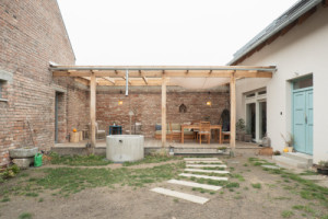 Dříve využívaný chlívek teď funguje jako technické zázemí sousedícího rodinného domu a zároveň malé wellness. (Terasa a zázemí ve stodole; tamti_architekti)