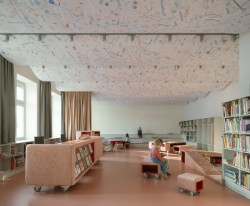 V oddělení pro děti je růžovo-červený mobiliář ještě hravější. Regály mají různé výšky, aby vyhovovaly různě starým dětem. (Knihovna v Červeném Kostelci; Papundekl architekti)