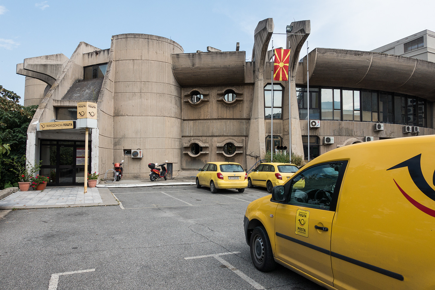 Jedna z nejznámnějších budov Tangova urbanistickému plánu je hlavní pošta. Tu vyprojektoval makendonský architekt Janko Konstantinov, který před svým návratem do vlasti v roce 1963 spolupracoval s Alvarem Aaltem. Pošta je postavena ze syrového betonu, který je zde použit drsně a ve velkém množství, ale v organických formách romantizujících tvarů. Ačkoliv jde o ryze brutalistickou stavbu, poště nechybí různé&nbsp;ozdoby, a to jak v samotné&nbsp;konstrukci, tak v interiéru