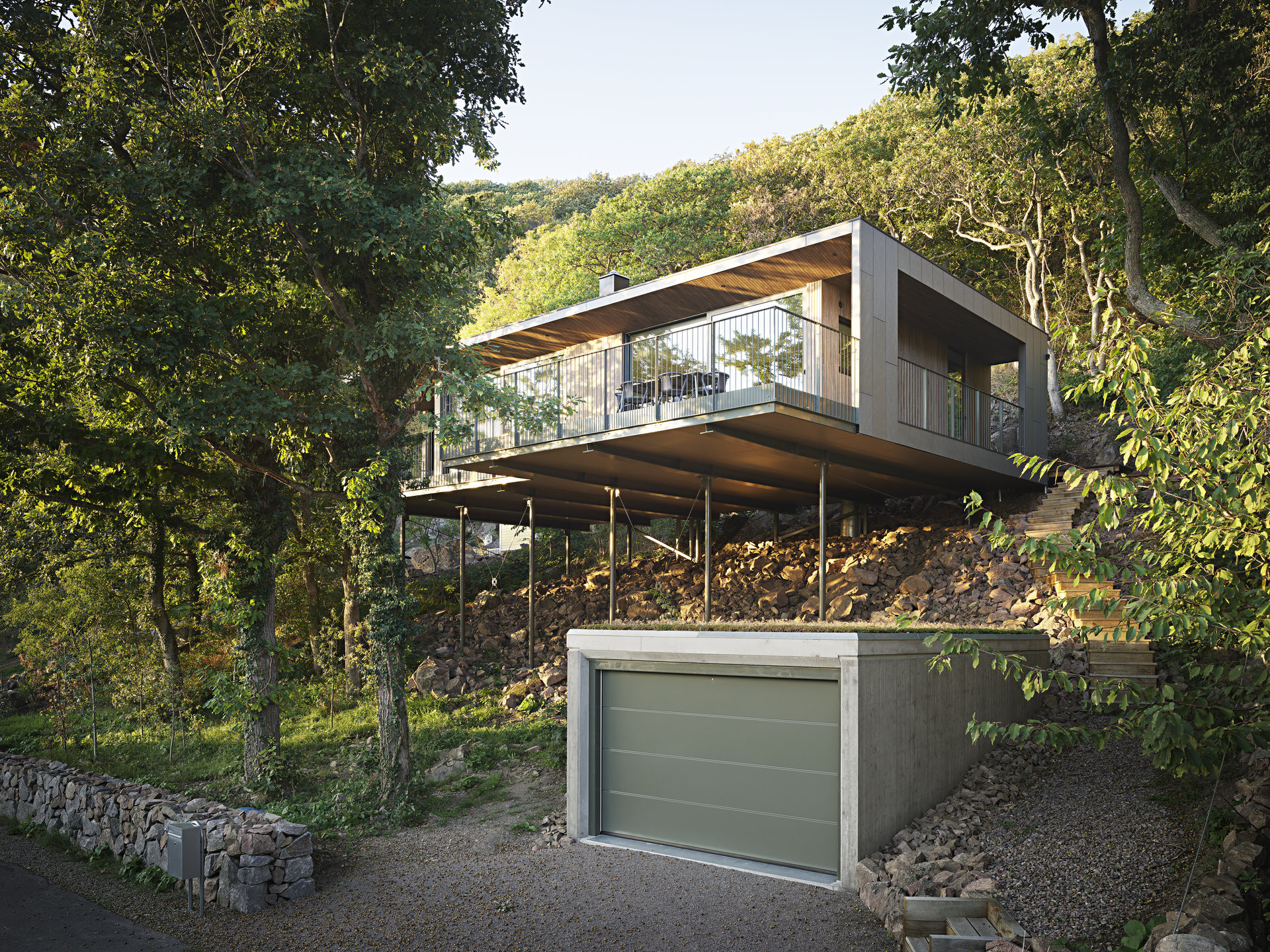 Dům má obývací pokoj mezi větvemi stromů.