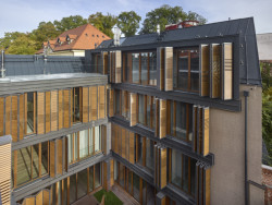 Ačkoliv se ze střechy otevírají daleké výhledy, dům není vyšší než jeho sousedi. (Rezidence Gotthardská v Praze, NEDVEDARCHITETI)