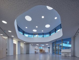 Vnitřní tvarování a barevnost podhledů působí jako vesmírná loď. (Školka Varnsdorf, RG architects studio)