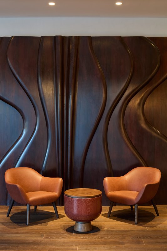 Dřevěná stěna od Josefa Klimeše v lobby hotelu
