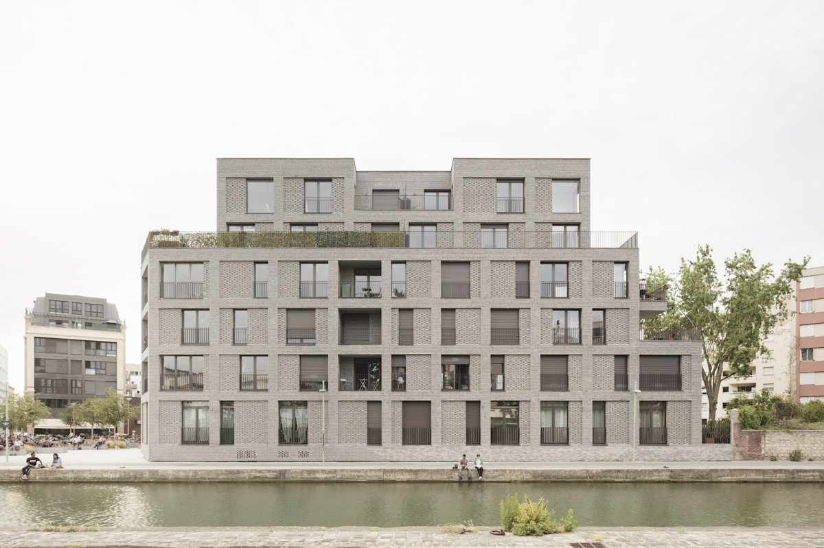Studio AVENIER CORNEJO architectes navrhlo na břehu kanálu na předměstí Paříže obytný soubor třech domů s různým odstínem lícových cihel