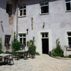 Na dvorku se také podařila položit nová dlažba. Nyní se tu nachází příjemné posezení. (Sadovsky & Architects, Apartmány v Rožnavě)