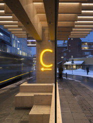 Jednotlivá nástupiště označují neonově svítící písmena. (Autobusové nádraží Umeå Vasaplan, Wingårdhs + WSP)