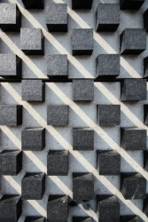 Fasádu válcové budovy pokrývají žulové kostky zasazené do betonové konstrukce. Projevuje se tady také charakteristický znak ticinské školy, práce s elementárními geometrickými tvary.