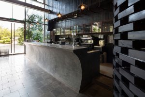 Stejný motiv skládání dřevěných bloků na sebe je použit i u stěny baru.(Restaurace Pizza 4P’s v Hanoji od česko – vietnamského studia ODDO)