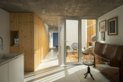 V západní části domu se nachází obývací pokoj s klavírem. (Úzký patrový dům v Žilině, architektonické studio treea - architekt Peter Kasman.)