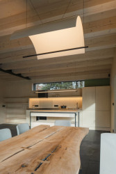 Hlavní obytnou místnost tvoří propojený obývací pokoj s kuchyní a jídelnou. (Chata na Šumavě, ateliér Markéty Cajthamlové)