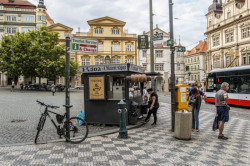 Architektura může být i méně ušlechtilá. Chybně umístěné stánky s občerstvením, nevzhledné koše, přehršel sloupů a sloupků a reklamy na nich – to všechno jsou věci, které nám otravují život, a tedy architektonické problémy. / Malostranské náměstí  – foto