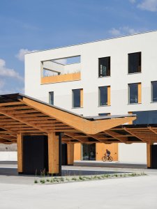 Přístřešky na parkovišti kryjí. (Kanceláře postavené z CLT panelů; Studio Perspektiv)