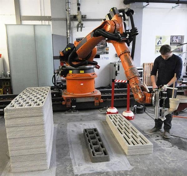 Obr. 30: Ukázka tisku vytlačováním cementové malty tiskárnou s využitím šestiosého průmyslového robota, TU Mnichov, Německo,