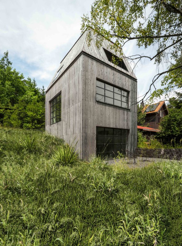 Stavba vertikální formy je umístěná v prudkém svahu tak, aby nebyl zásah do terénu v místě téměř patrný. (Chata JARO u Prahy, edit! architects)