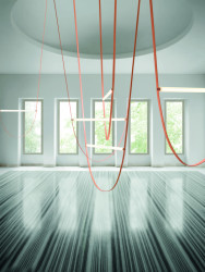 Svítící trubice z bílého mléčného skla a mléčného polykarbonátu disponuje 130 cm dlouhou svítící plochou. Závěs z gumy je variabilní, co se týče délky 65 – 295 cm.