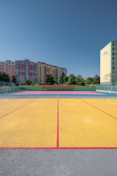 Architekti barevný nátěr navrhli aby zatraktivním původně jen šedou vybetonovanou plochu hřiště. (Vnitroblok Manětínská v Plzni, Sporadical)