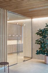 Wellness centrum lázní Aurora v Třeboni, Plus One Architects: Použily béžové dlaždice, drcený kámen a dřevo.