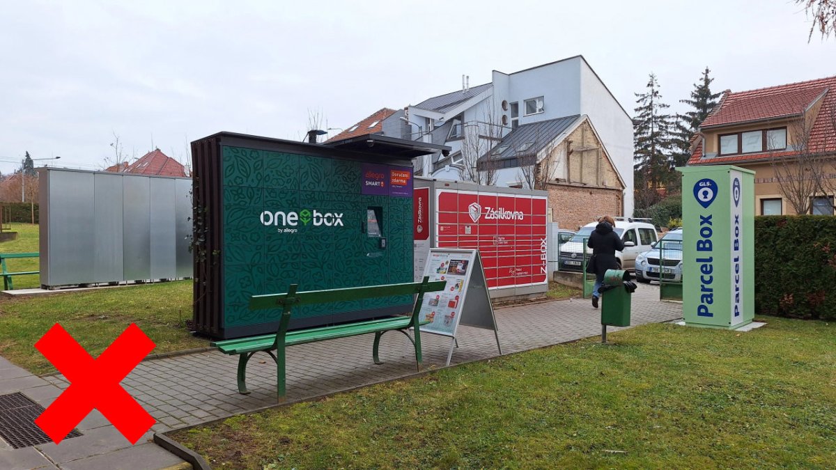 Shluky různorodých boxů vytváří dominantní prvek v prostoru. Nesourodé polepy, stříšky a patky navíc vytváří vizuální smog. Zde je okolí boxů "vylepšeno" ještě áčkovým reklamním poutačem.