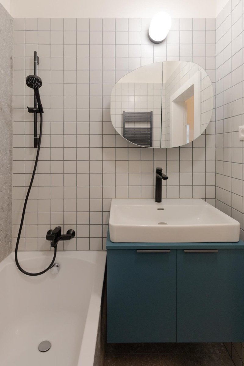 Koupelna je účelně řešena a navazuje na barevné a materiálové řešení bytu. - Rekonstrukce bytu v Praze - Holešovicích, Studio Schwestern.