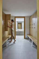 Obsahuje veškeré potřebné zázemí včetně šaten se skříňkami a menší jógový sál. (Quis Yoga Studio v Praze-Petřinách, MENU architekti)