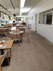 V prostoru zadní terasy restaurace a u venkovního bazénu klubu je použita béžová dlaždice Piazzetta Outdoor od značky RAKO, která dokonale podtrhuje celkové architektonické řešení