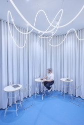 Část pro zákazníky a zázemí oddělují světle šedivé závěsy. (Provozovna v pasáži Černá růže, RDTH architekti)