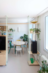 Vizuálně kuchyni odděluje lehká policová stěna se dvěma průchody. (Byt v paneláku od hurá studio)