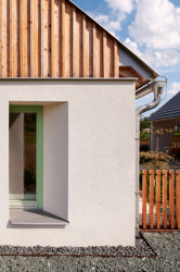 Fasáda je navržena z bílé omítky s doplněním dřevěných štítů.