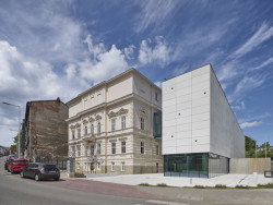 Stavby stojí v náročné urbanistické situaci – přímo u kruhového objezdu a vedle parkoviště. (Interaktivním centru pohádek a animace OKO v Bílsko-Bělé v Polsku, Nizio Design International)