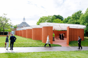 LANZA atelier zvolil překvapivě jednoduchý přístup: skromnou oranžovou stěnu tlustou na jednu cihlu. (Serpentine Pavilion 2026; LANZA atelier)