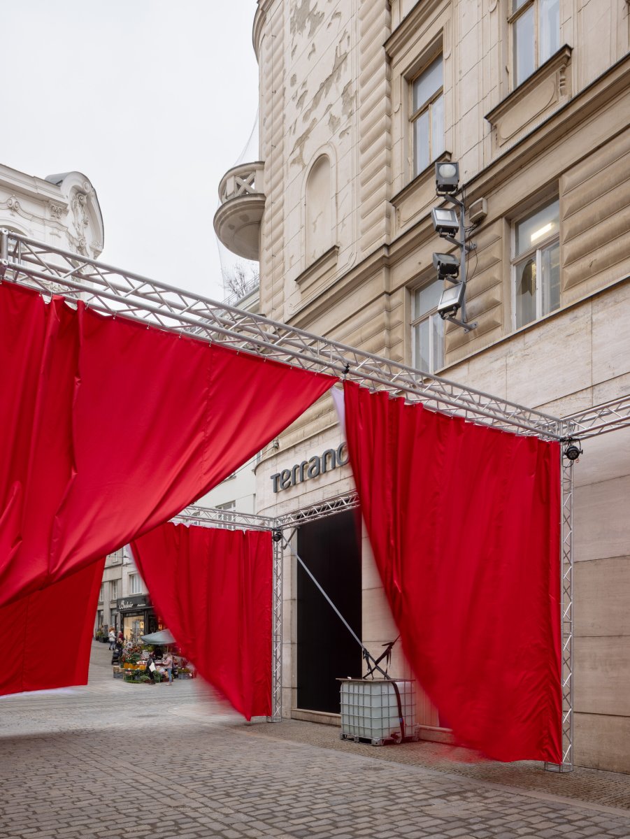 Opony visí na konstrukci, z níž se běžně budují pódia. (Peer Collective a Kateřina Šedá, Festival vánočních zlozvyků)