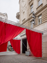 Opony visí na konstrukci, z níž se běžně budují pódia. (Peer Collective a Kateřina Šedá, Festival vánočních zlozvyků)