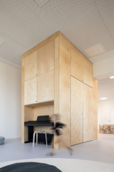 Rekonstrukce mateřské školy Polánka, ateliér CL3: Ve vysoké skříni, která má i šikovný výklenek na klavír, jsou uskladněné dětské postýlky