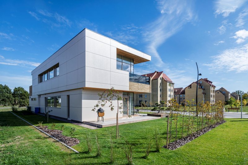 Obytná budova Sandy Cuboid v Birštonasu v Litvě, na jejíž fasádě je z velké části použito obložení panely Swisspearl Largo Reflex v béžovém odstínu.