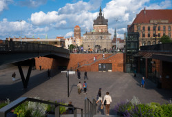 Za hradbami starého města, které dnes už odděluje jen Zlatá brána, dříve býval trh s dobytkem, později autobusové nádraží. Dnes je plac Targ Sieny moderní nákupní čtvrtí.