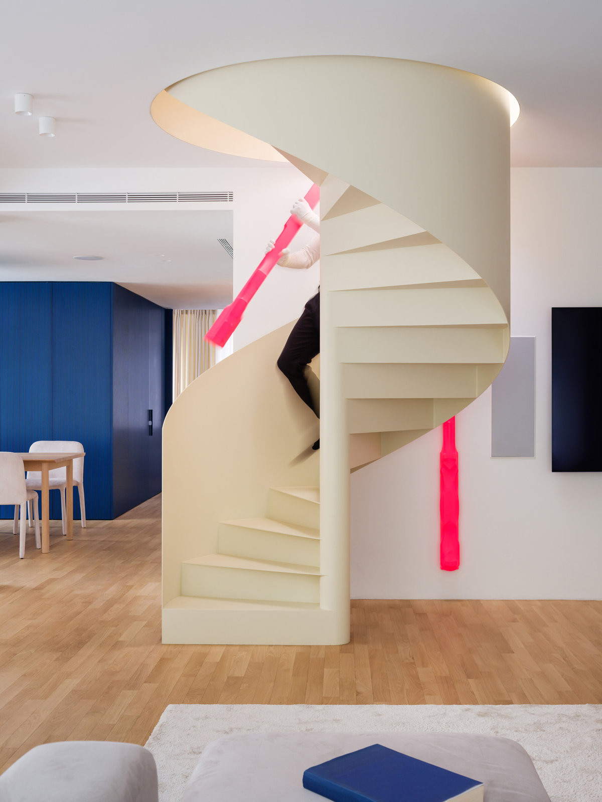 Točité schodiště obklopují neonové plastiky Petra Duba. (Mezonet na Břevnově; esté architekti)