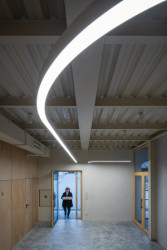 Nové ocelové konstrukce v tlumené bílé barvě. (Komunitní centrum v bývalé stodole, studio Raketoplán)