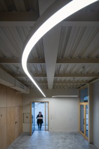 Nové ocelové konstrukce v tlumené bílé barvě. (Komunitní centrum v bývalé stodole, studio Raketoplán)