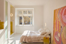 V největším prostoru bytu je postel, nejvíce pozornosti ovšem upoutává obraz – dílo majitelky bytu a malířky Lucie Michnové. (Byt pro malířku v Praze-Holešovicích od Plus One Architects)