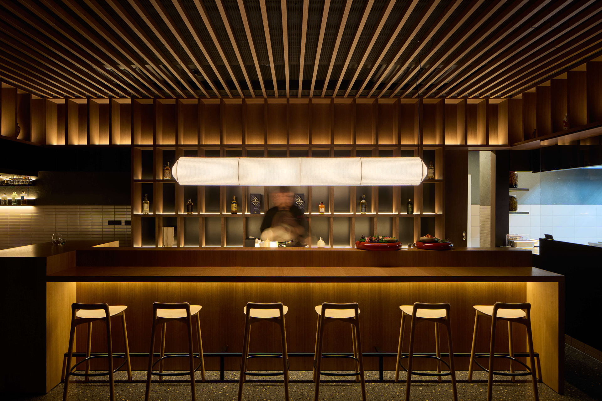 Pozornost se v interiéru stahuje k ústřednímu pultu mistra sushi. (Restaurace Hansik v Praze; Neuhäusl Hunal)