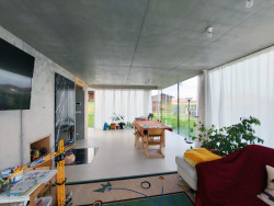 Dům s rampou, Prokš Přikryl: Soukromé patro s ložnicí a pokoji v bílé a dřevě spočívá na „lehkém“ a do zahrady maximálně otevřeném společenském prostoru se stropem a stěnami z přiznaného betonu