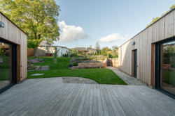 Rodinný dům v Bystřici nad Perštejnem, studio AEIOU: Novostavba má dvě tváře, směrem do ulice je omítnutá, podobně jako sousední domy, do zahrady má pak celou fasádu obloženou dřevem