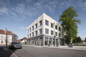 Detail vztahu budovy k náměstí - objekt působí jako přirozený organizující prvek veřejného prostoru. (Nová radnice s plastickou fasádou; re:architekti)