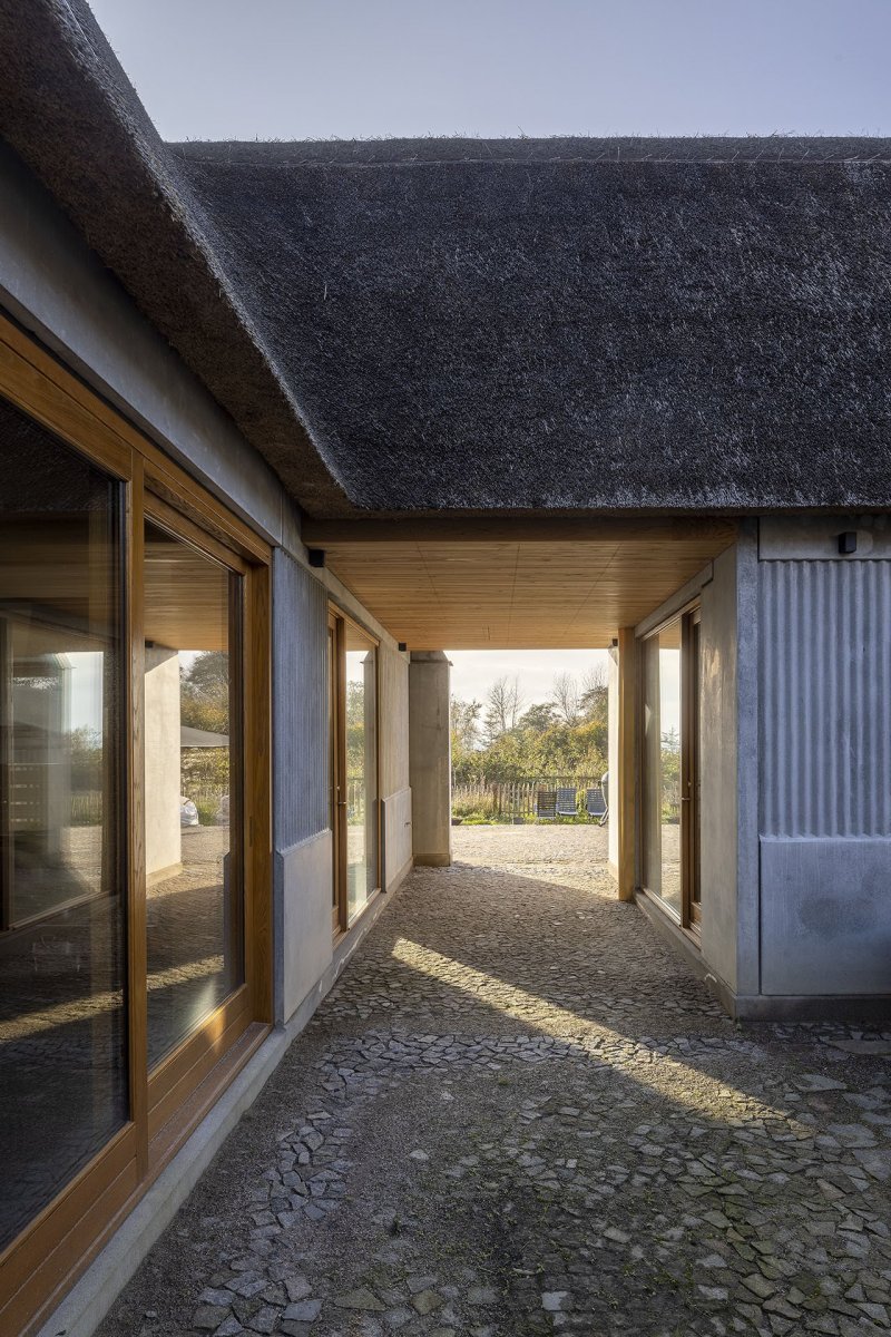 Dům nabízí výhledy do krajiny i průhledy mezi vnitřními prostory. (Åstrup Have, NORRØN Architects)