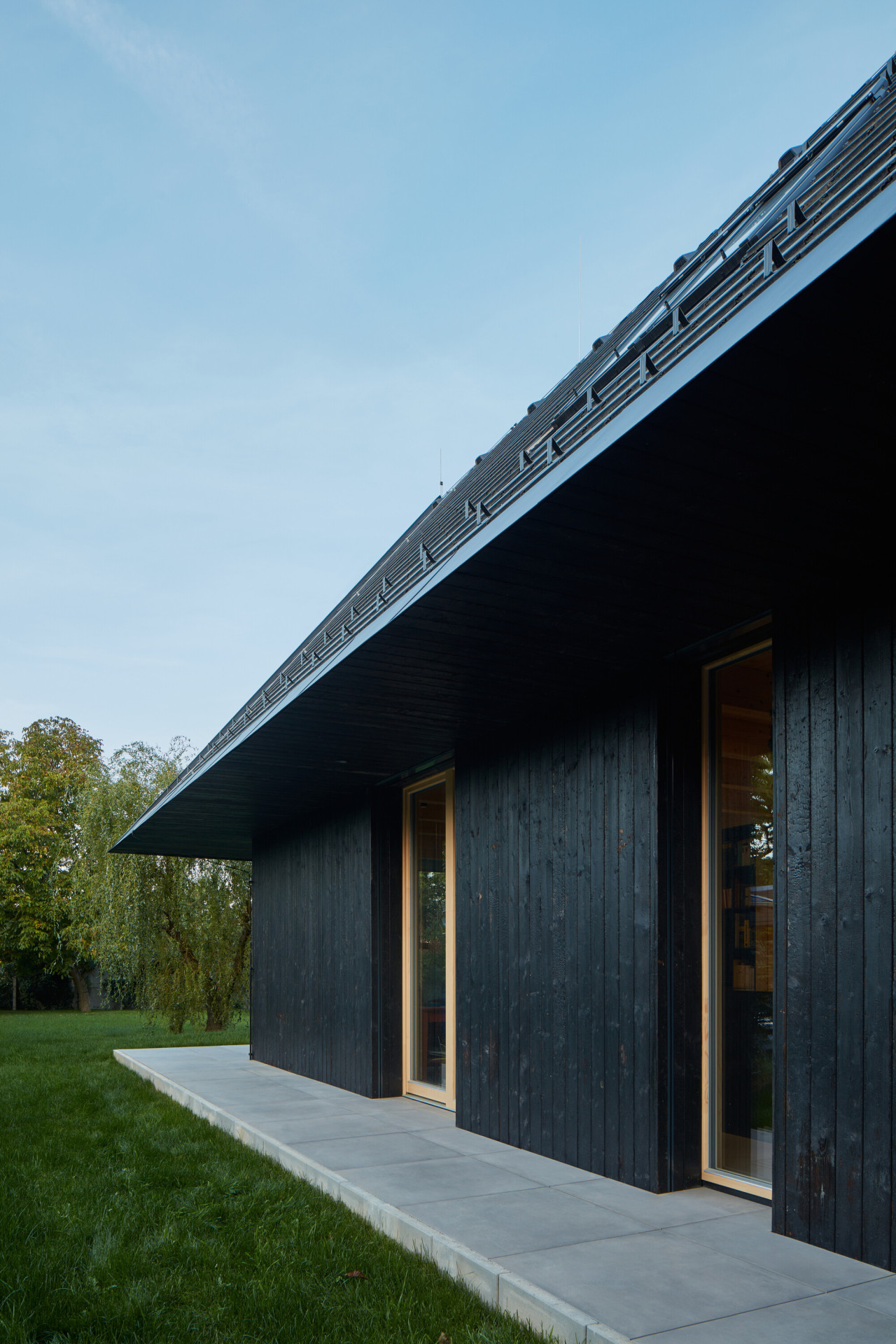 Dům v Říčanech, ateliér Hajný: Přesah střechy stíní jižní fasádu.