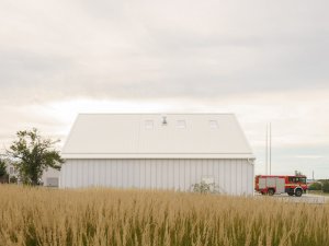 Fasáda je z bílého polykarbonátu. (Hasičská stanice Dolní Jirčany, SOA architekti)
